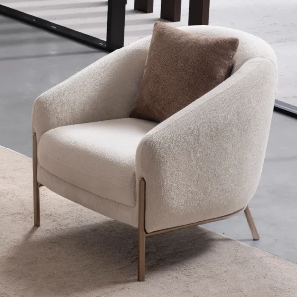 Elora Armchair featuring a curved tub-style silhouette, cozy throw cushion, and slim metal legs.