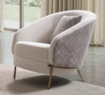 Lina Armchair featuring a curved barrel-style backrest, patterned outer upholstery, and slim metal legs.