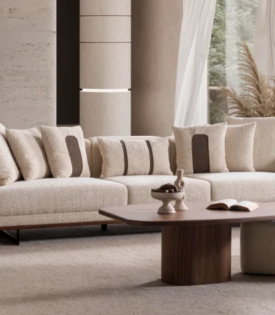 Sola Three Seater Sofa featuring rounded armrests, plush back cushions, and a wooden base trim in a modern living room setting.