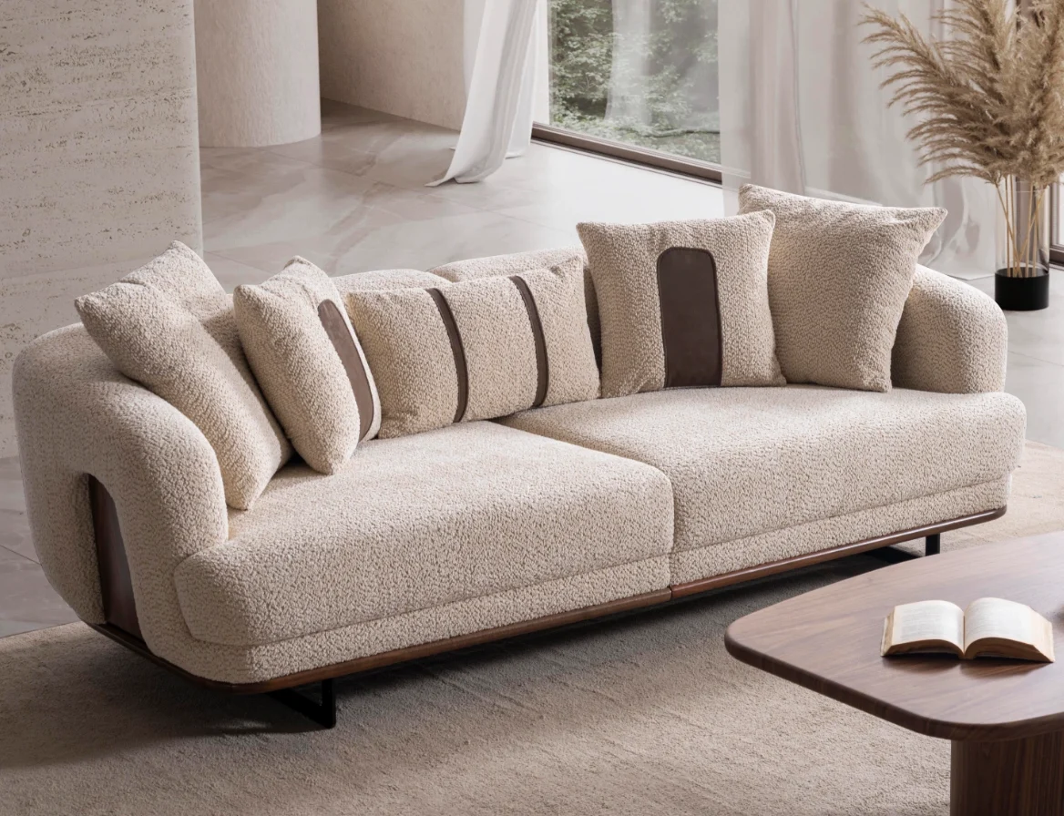 Sola two seater sofa cozy boucl textured sofa Sofaturkey living room furniture sofa 8 Sola Two Seater Sofa featuring rounded armrests, plush back cushions, and a wooden base trim in a modern living room setting.