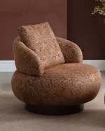 Tolia Armchair sculptured round swivel armchair featuring intricate paisley pattern upholstery and a plush back cushion.