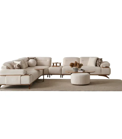 A modern living room featuring the Grace Sofa. The arrangement displays a plush taupe sofa and a matching cream sofa, both designed with distinctive integrated wooden side tables on the armrests and angled wooden legs. A white swivel armchair and a round wooden coffee table complete the cozy, contemporary look of this furniture from Turkey.