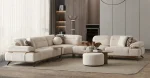 A modern living room featuring the Grace Sofa. The arrangement displays a plush taupe sofa and a matching cream sofa, both designed with distinctive integrated wooden side tables on the armrests and angled wooden legs. A white swivel armchair and a round wooden coffee table complete the cozy, contemporary look of this furniture from Turkey.