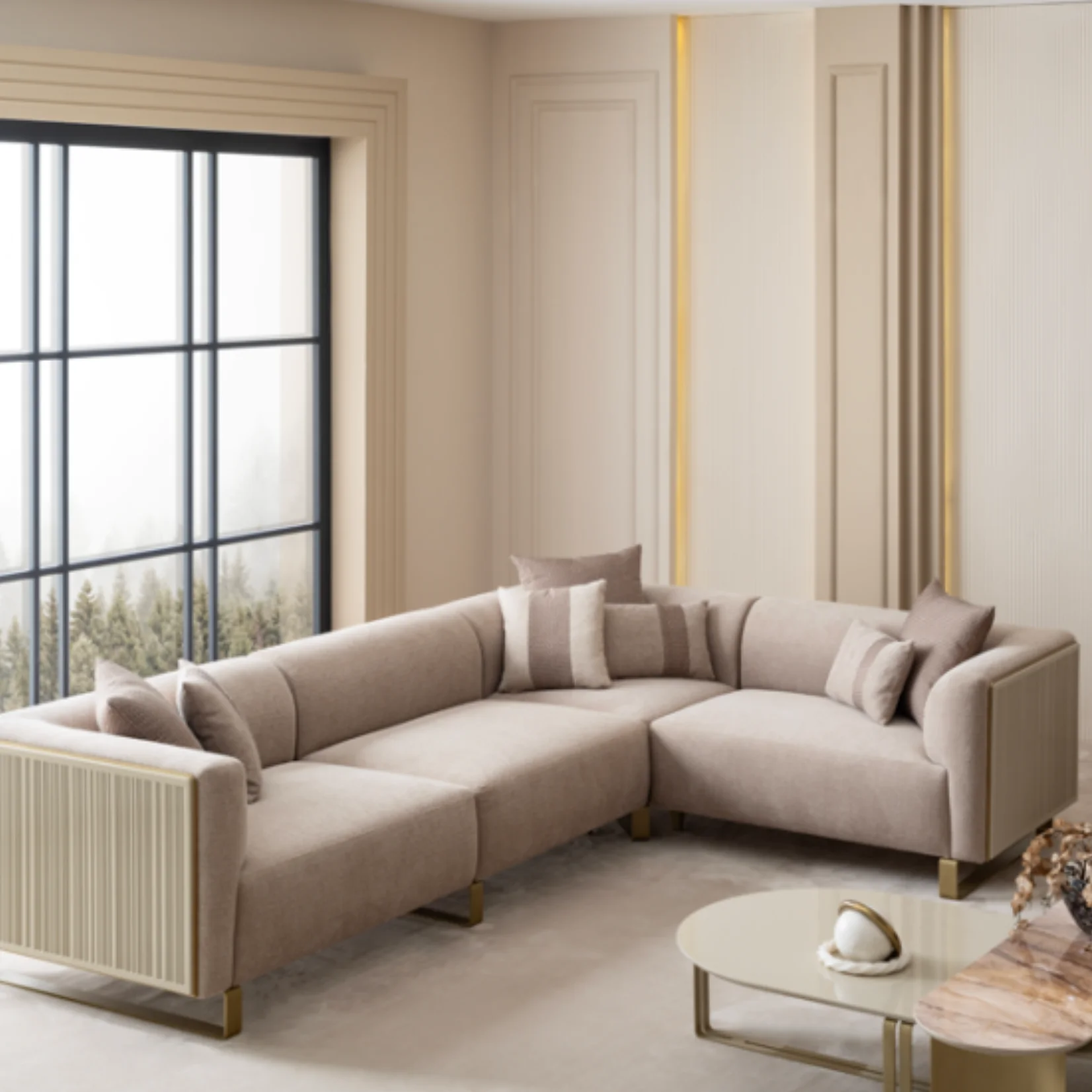 Grandeur-Corner-Sofa-3 A luxurious modular Grandeur sofa set in a bright, modern living room. The set features cream-colored fabric upholstery with rectangular cushions and sleek gold metallic legs. Beside the modular sections sits a matching rounded armchair with gold accents. The scene includes minimalist decor, a marble coffee table, and large windows, highlighting the elegant design of the Grandeur furniture from Turkey.