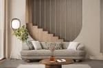 Premium sand grey curved sofa with sculptural round wooden legs and decorative cushions