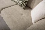Premium sand grey curved sofa with sculptural round wooden legs and decorative cushions