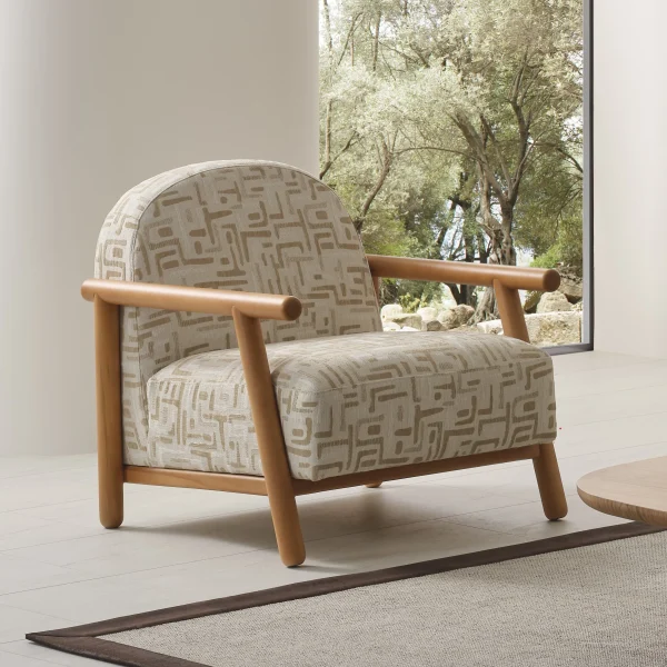 The organic Areon Armchair featuring textured fabric and wooden legs, placed in a bright, minimalist living room that evokes a sense of natural harmony and peace.