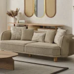 The organic Areon Sofa featuring textured fabric and wooden legs, placed in a bright, minimalist living room that evokes a sense of natural harmony and peace.