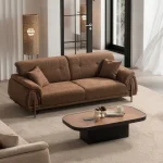 A modern textured fabric sofa featuring linear tufted backrest detailing, soft rounded side armrests supported by slim elegant wooden-accent legs, set in a spacious high-ceiling living room environment.