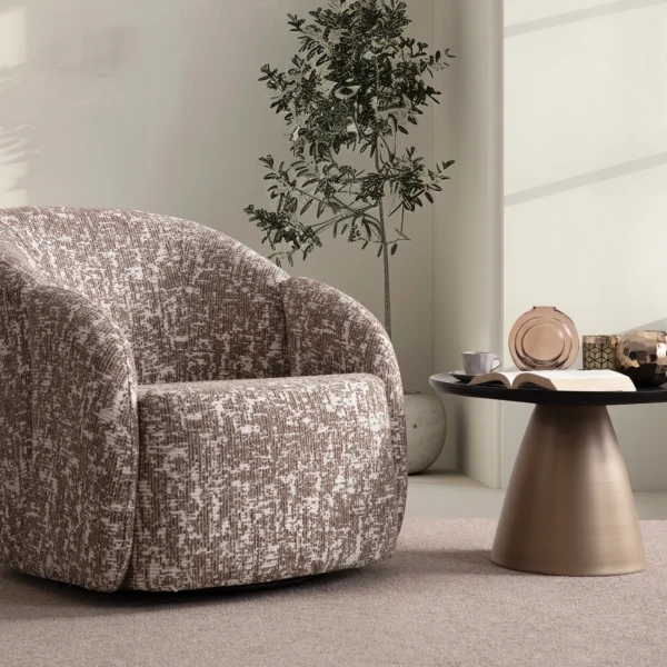 A modern tub-style accent armchair featuring a curved continuous barrel backrest, textured woven upholstery pattern, and a fully upholstered low-profile base set in a sunlit contemporary room layout.