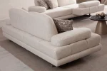 A modern textured fabric sofa featuring linear tufted backrest detailing, soft rounded side armrests supported by slim elegant wooden-accent legs, set in a spacious high-ceiling living room environment.