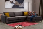 Bria Corner Sofa modern charcoal grey sectional sofa featuring quilted outer armrests, colorful throw pillows, and wooden legs.