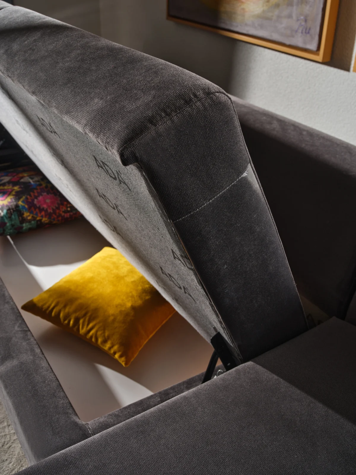 Bria Corner Sofa modern charcoal grey sectional sofa featuring quilted outer armrests, colorful throw pillows, and wooden legs.