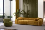 The Rio Sofa set featuring a deep-seated mustard yellow sofa and a matching forest green sofa with plush corduroy-style texture, complemented by a unique curved green armchair in a bright, modern penthouse.