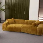 The Rio Sofa set featuring a deep-seated mustard yellow sofa and a matching forest green sofa with plush corduroy-style texture, complemented by a unique curved green armchair in a bright, modern penthouse.