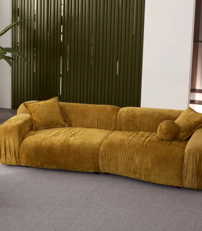 The Rio Sofa set featuring a deep-seated mustard yellow sofa and a matching forest green sofa with plush corduroy-style texture, complemented by a unique curved green armchair in a bright, modern penthouse.