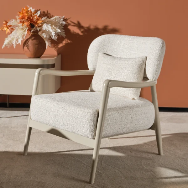 Cora Armchair with an exposed wooden frame and softly curved backrest.