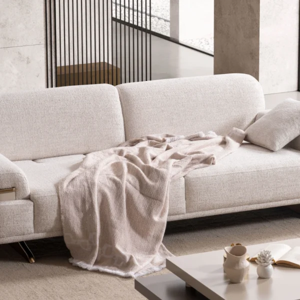 Cora Sofa styled in a modern interior setting with curved armrests and a wide seating surface.