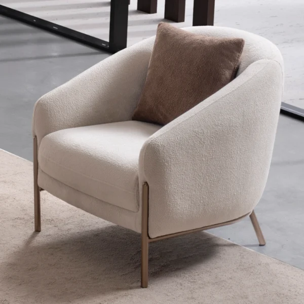 Elora Armchair featuring a curved tub-style silhouette, cozy throw cushion, and slim metal legs.