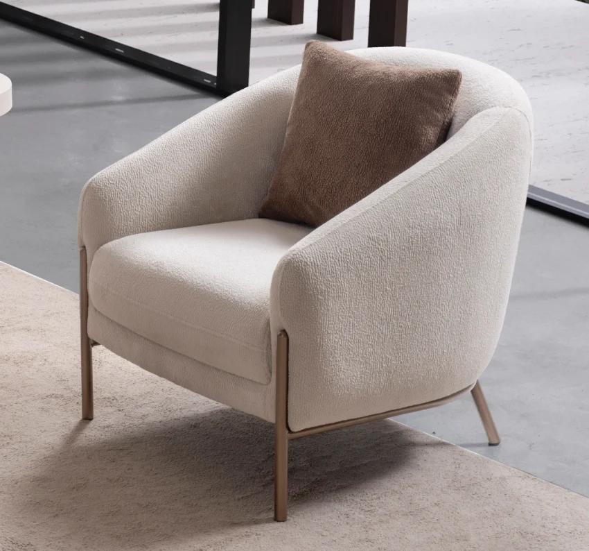 Elora-armchair 1 Elora Armchair featuring a curved tub-style silhouette, cozy throw cushion, and slim metal legs.