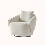 A modern living room featuring the Grace Sofa. The arrangement displays a plush taupe sofa and a matching cream sofa, both designed with distinctive integrated wooden side tables on the armrests and angled wooden legs. A white swivel armchair and a round wooden coffee table complete the cozy, contemporary look of this furniture from Turkey.