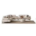 A modern living room featuring the Grace Sofa. The arrangement displays a plush taupe sofa and a matching cream sofa, both designed with distinctive integrated wooden side tables on the armrests and angled wooden legs. A white swivel armchair and a round wooden coffee table complete the cozy, contemporary look of this furniture from Turkey.