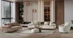 A modern living room featuring the Grace Sofa. The arrangement displays a plush taupe sofa and a matching cream sofa, both designed with distinctive integrated wooden side tables on the armrests and angled wooden legs. A white swivel armchair and a round wooden coffee table complete the cozy, contemporary look of this furniture from Turkey.