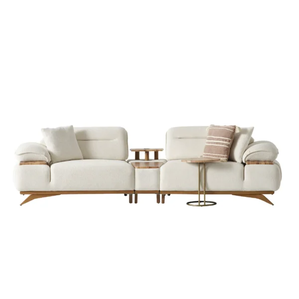A modern living room featuring the Grace Sofa. The arrangement displays a plush taupe sofa and a matching cream sofa, both designed with distinctive integrated wooden side tables on the armrests and angled wooden legs. A white swivel armchair and a round wooden coffee table complete the cozy, contemporary look of this furniture from Turkey.