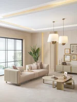 A luxurious modular Grandeur sofa set in a bright, modern living room. The set features cream-colored fabric upholstery with rectangular cushions and sleek gold metallic legs. Beside the modular sections sits a matching rounded armchair with gold accents. The scene includes minimalist decor, a marble coffee table, and large windows, highlighting the elegant design of the Grandeur furniture from Turkey.