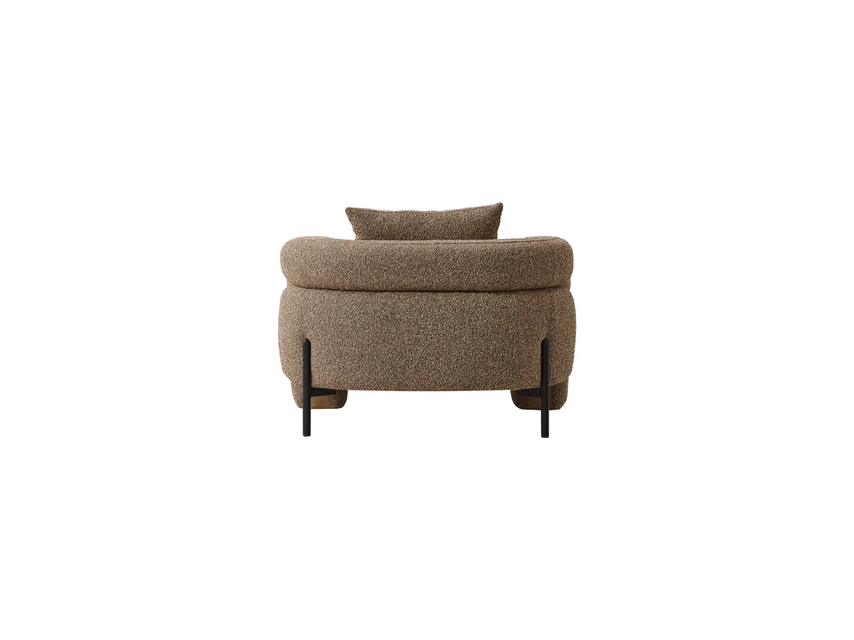 The distinguished Harmoni Armchair in a bright, modern interior with curved architectural details and warm brown accents, embodying a sense of balance and harmony.