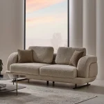 The distinguished Harmoni Sofa in a bright, modern interior with curved architectural details and warm brown accents, embodying a sense of balance and harmony.