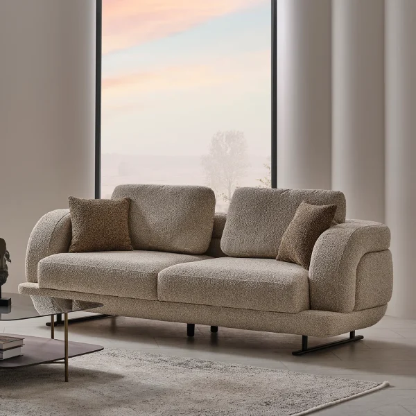 The distinguished Harmoni Sofa in a bright, modern interior with curved architectural details and warm brown accents, embodying a sense of balance and harmony.