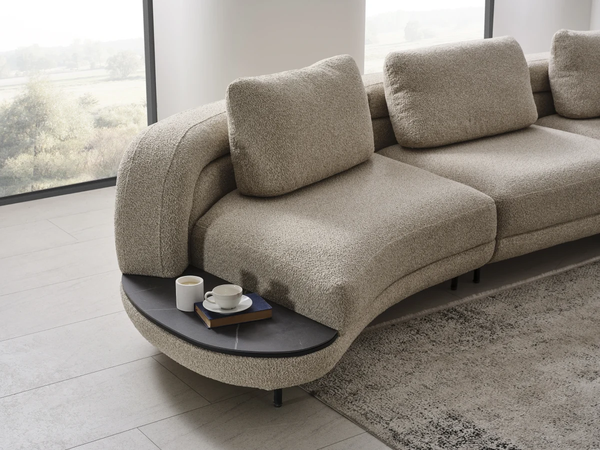 Harmoni Sofa 3-Seater Curve Edition featuring a sophisticated organic silhouette, premium textured bouclé fabric, and a sleek integrated minimalist side table on a low-profile base.