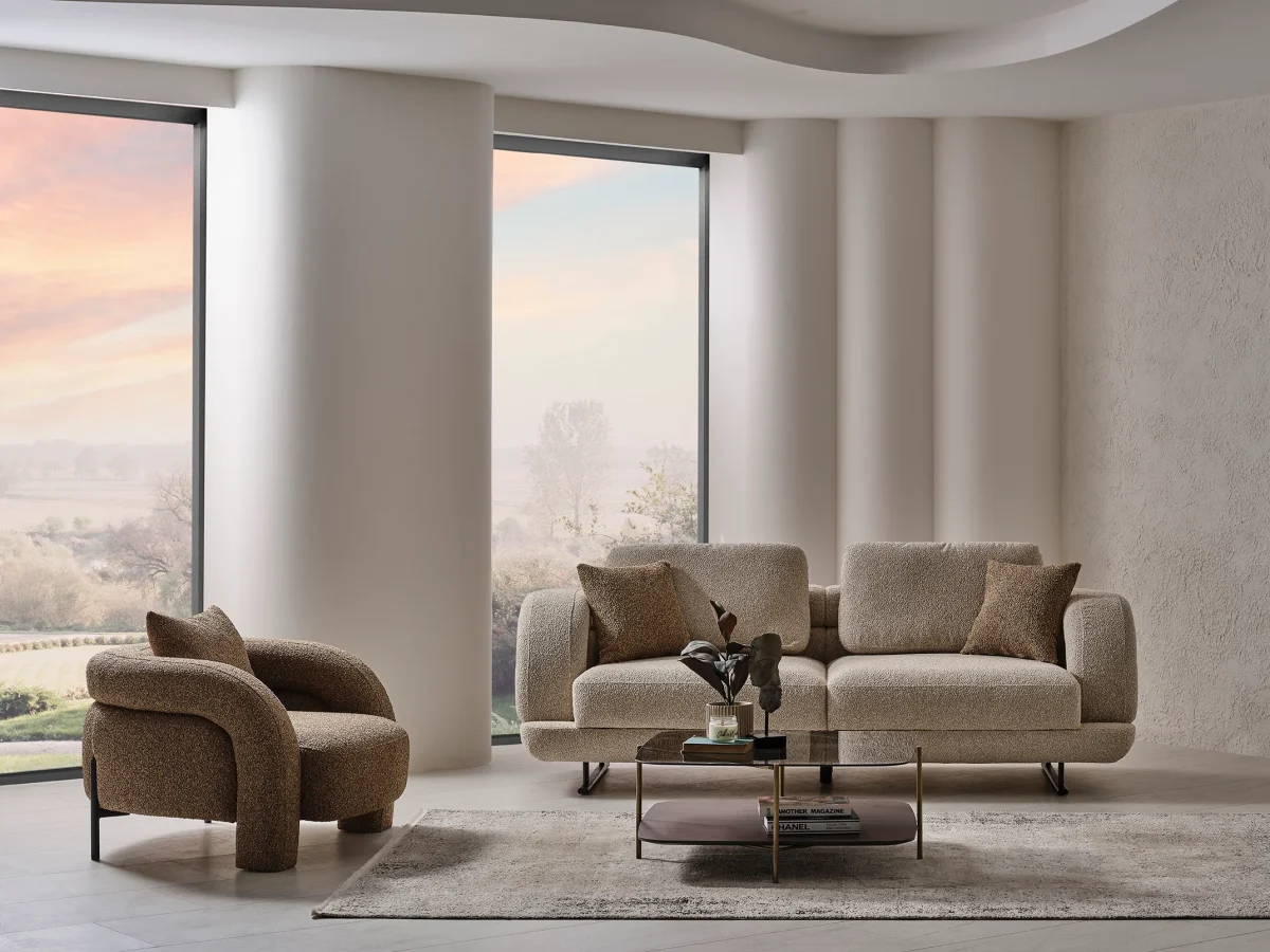 Modern fabric sofa set with rounded design, beige three-seater sofa and brown armchair, black metal legs, contemporary living room setting