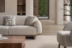 Modern rounded sofa with white boucle fabric and wooden base, luxury turkish furniture.