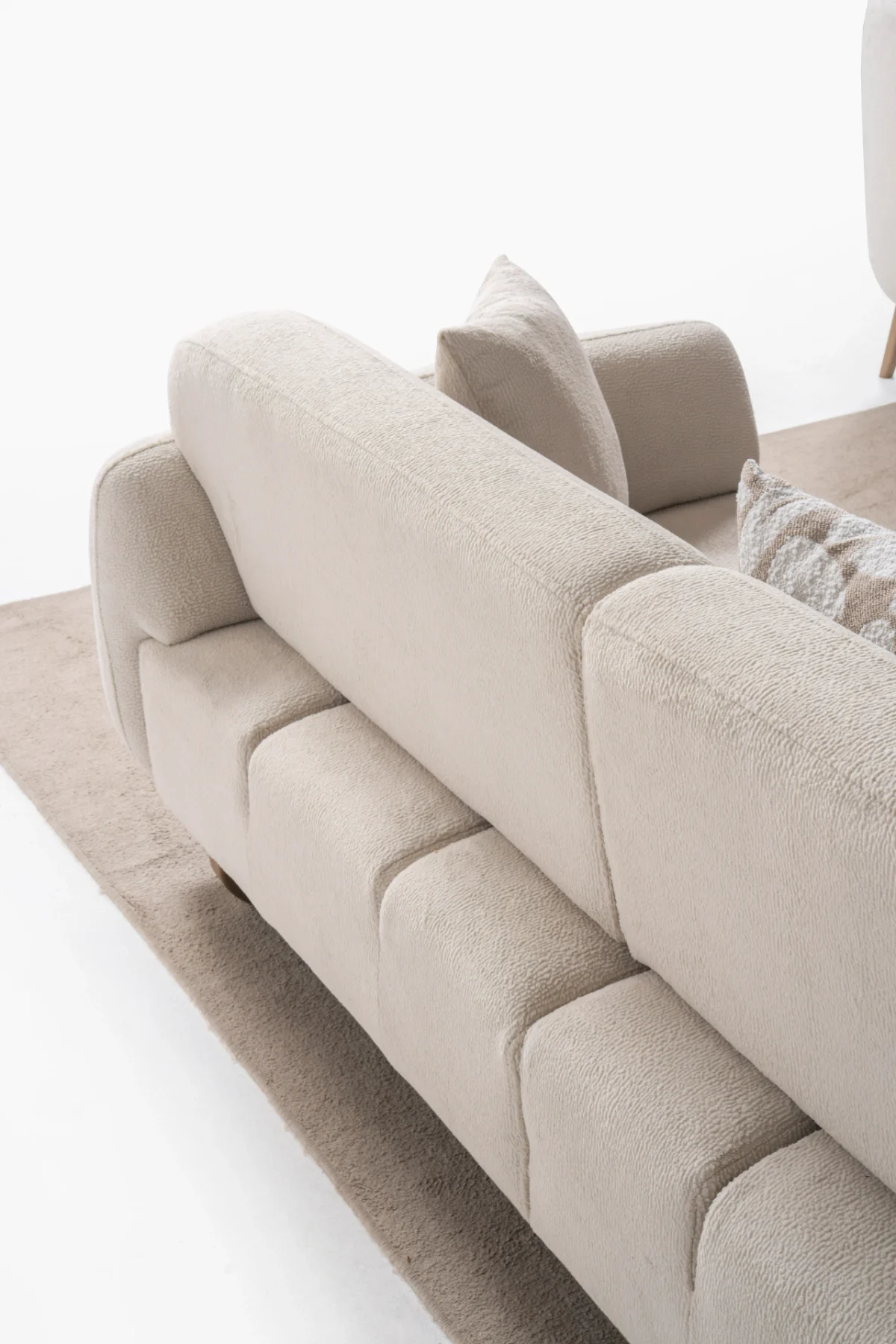Modern rounded sofa with white boucle fabric and wooden base, luxury turkish furniture.