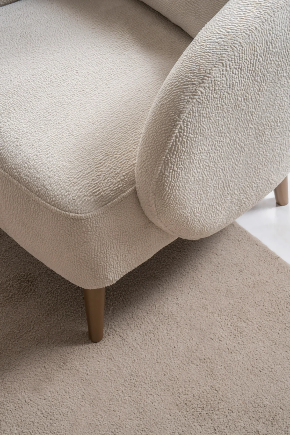 Laos Armchair - Minimalist rounded boucle accent chair with tapered wooden legs.