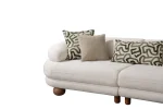 Premium sand grey curved sofa with sculptural round wooden legs and decorative cushions