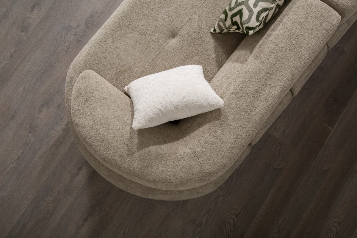 Premium sand grey curved sofa with sculptural round wooden legs and decorative cushions