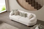 Premium sand grey curved sofa with sculptural round wooden legs and decorative cushions