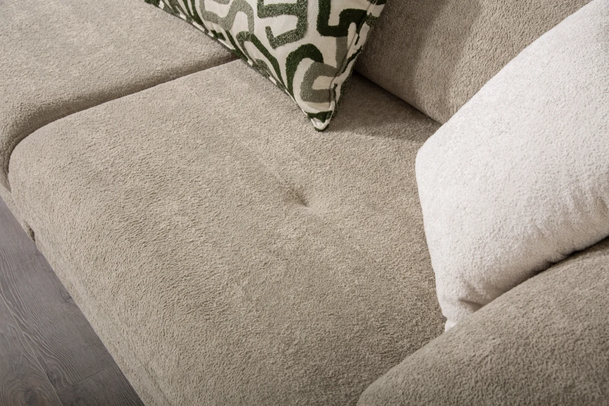 Premium sand grey curved sofa with sculptural round wooden legs and decorative cushions