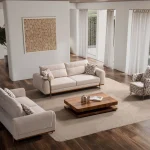 A complete modern living room sofa set composed of two spacious multi-seater sofas with integrated metal side trays and a matching accent armchair with geometric pattern upholstery, centered around a warm wooden coffee table.