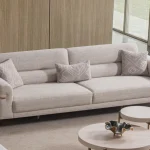 Lina Three Seater Sofa featuring distinct armrest accents, metallic leg details, and a spacious seat cushion layout.