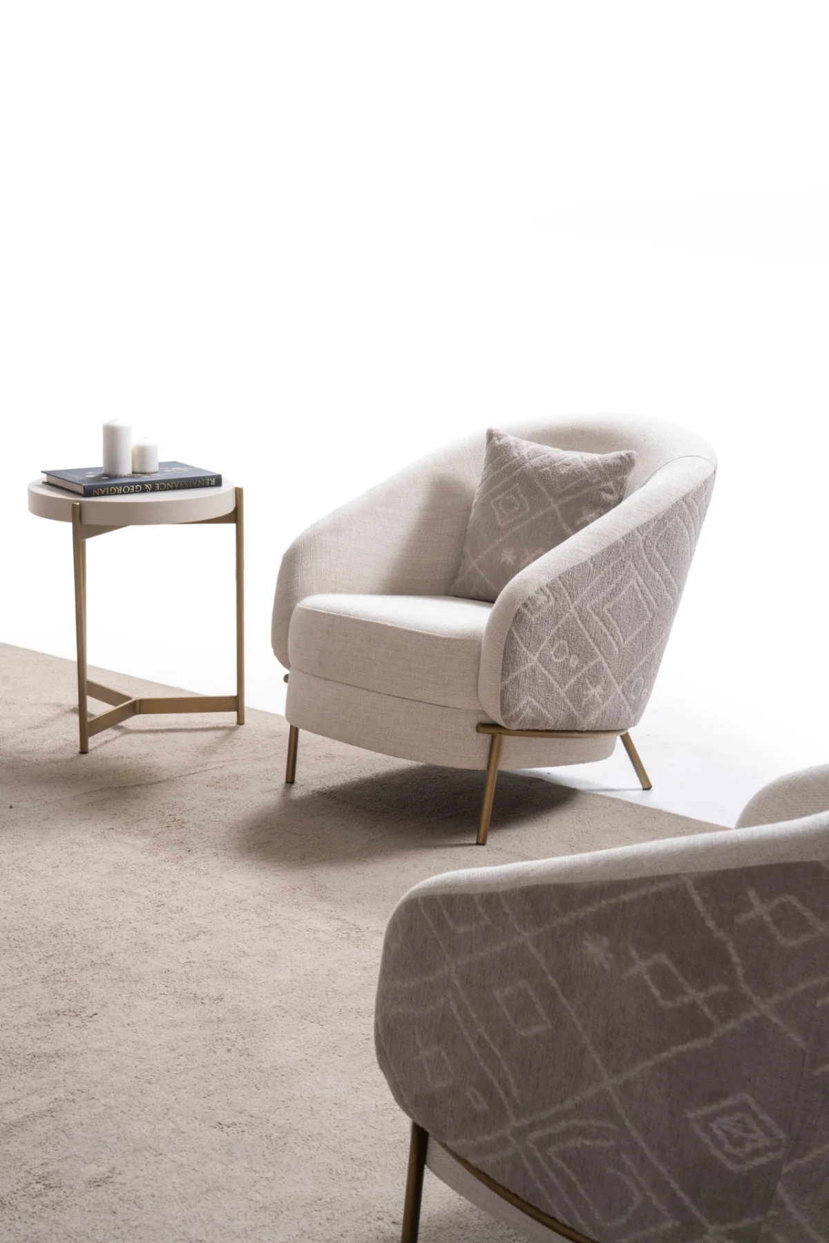 Lina Armchair featuring a curved barrel-style backrest, patterned outer upholstery, and slim metal legs.