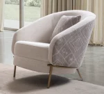 Lina Armchair featuring a curved barrel-style backrest, patterned outer upholstery, and slim metal legs.