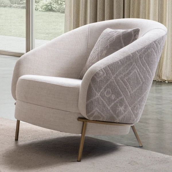 Lina Armchair featuring a curved barrel-style backrest, patterned outer upholstery, and slim metal legs.