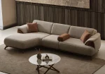 Loria Chaise Corner Sofa – 3 Modules three-piece modern beige sectional sofa featuring an extended chaise lounge, warm wooden arm details, terracotta accent pillows, and dark wooden legs.
