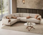 Loria Corner Sofa – 4 Modules four-piece sectional sofa in light beige upholstery featuring wooden armrest details, terracotta bolster cushions, and natural wooden legs.