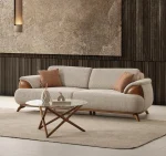 Loria Sofa combines organic curved contours, refined wooden armrest accents, and plush seating comfort to elevate modern living interiors. Experience premium quality with SofaTurkey™️.