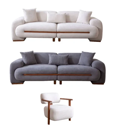 Nile Sofa Set featuring a large cream-colored bouclé sofa, a matching grey loveseat, and a stylish accent chair with wooden arms. The furniture is arranged in a high-end modern interior with textured stone walls and artistic lighting.